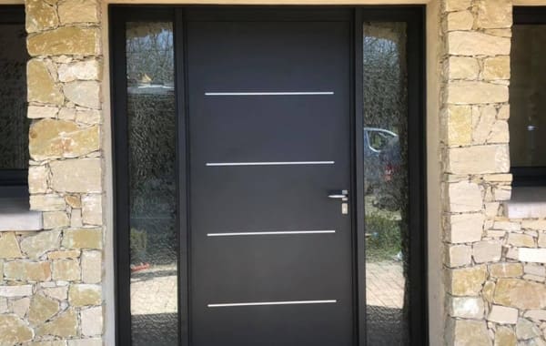 Une porte d'entrée avec 2 vantaux vitrés pour une rénovation de maison en pierres par Rémy Ferere.